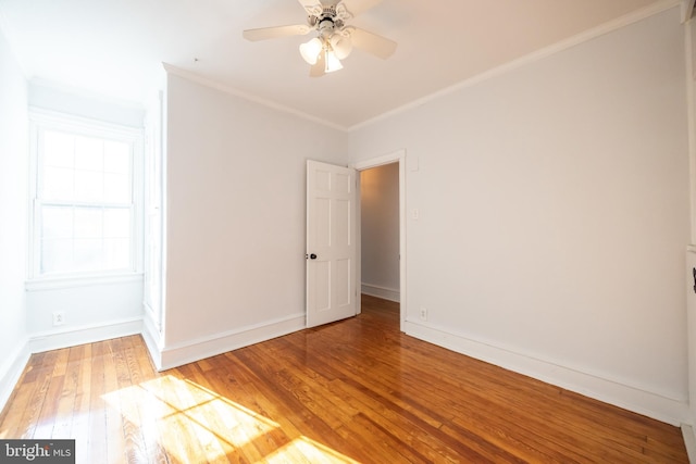 empty room featuring ceiling fan, baseboards, light wood-style floors, and ornamental molding