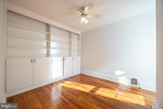 unfurnished bedroom with visible vents, crown molding, ceiling fan, and hardwood / wood-style flooring