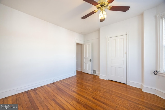 unfurnished bedroom featuring visible vents, baseboards, ceiling fan, and hardwood / wood-style flooring