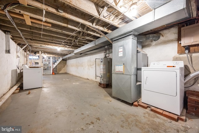 unfinished below grade area with gas water heater, heating unit, stairs, and washing machine and clothes dryer