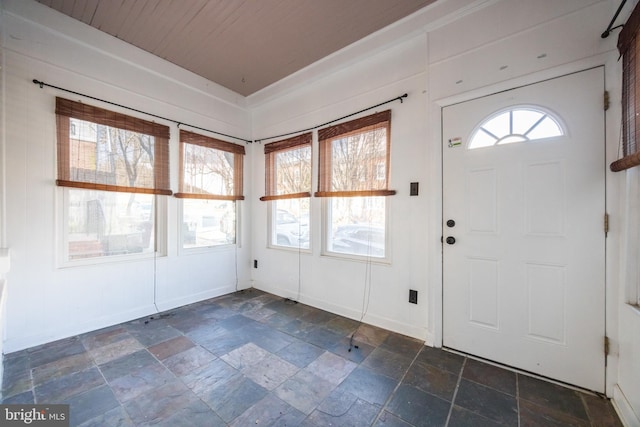 foyer featuring stone tile floors and baseboards