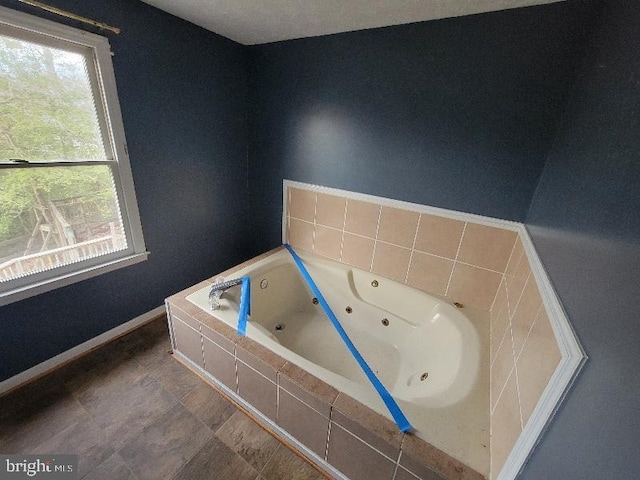 bathroom featuring a jetted tub and baseboards