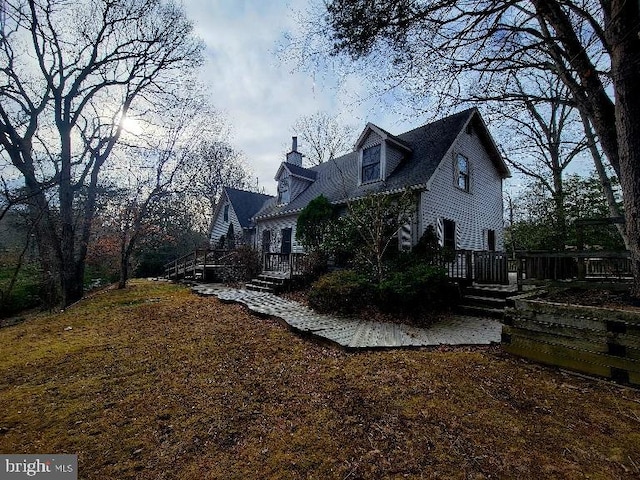 view of home's exterior featuring a chimney and a wooden deck