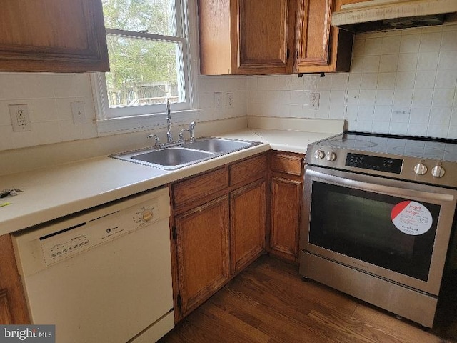 kitchen with brown cabinetry, stainless steel electric stove, a sink, dishwasher, and exhaust hood