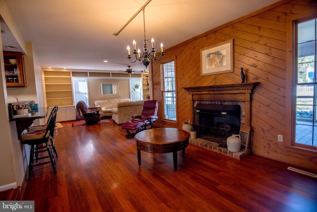 living room with an inviting chandelier, wood finished floors, plenty of natural light, and a fireplace