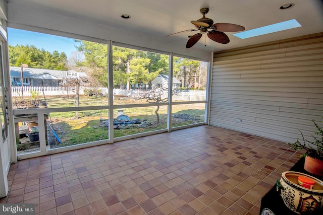 unfurnished sunroom with a skylight and a ceiling fan