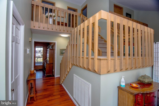 staircase featuring visible vents, baseboards, and wood finished floors