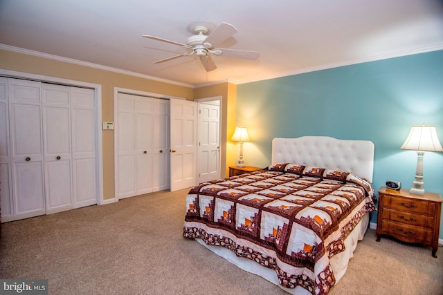 bedroom with ceiling fan, multiple closets, carpet floors, and ornamental molding