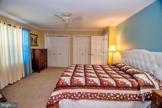 carpeted bedroom with multiple closets, ceiling fan, and crown molding