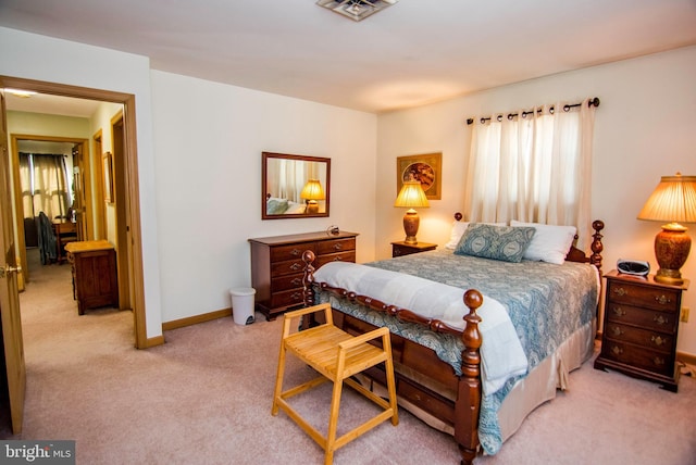 bedroom featuring visible vents, light colored carpet, and baseboards