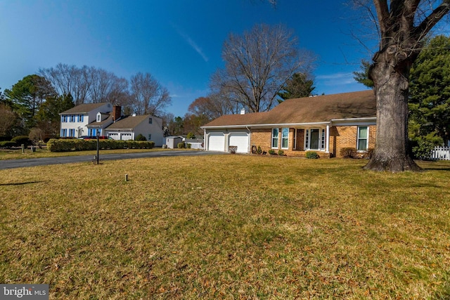 single story home featuring a front lawn, aphalt driveway, fence, an attached garage, and brick siding