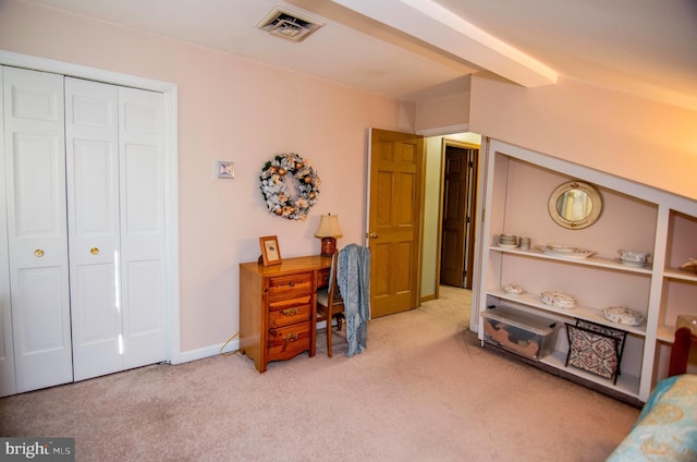 carpeted bedroom with a closet, visible vents, and baseboards