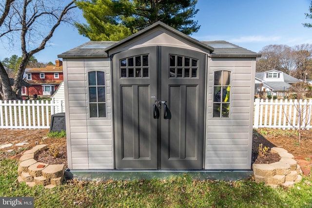 view of shed featuring fence