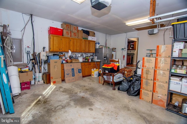 garage featuring a garage door opener and stainless steel fridge with ice dispenser