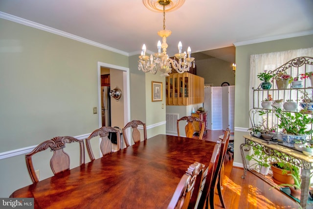 dining space with visible vents, a notable chandelier, wood finished floors, and crown molding