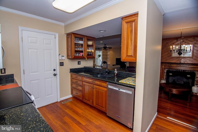 kitchen with wood finished floors, ornamental molding, a sink, dishwasher, and brown cabinets