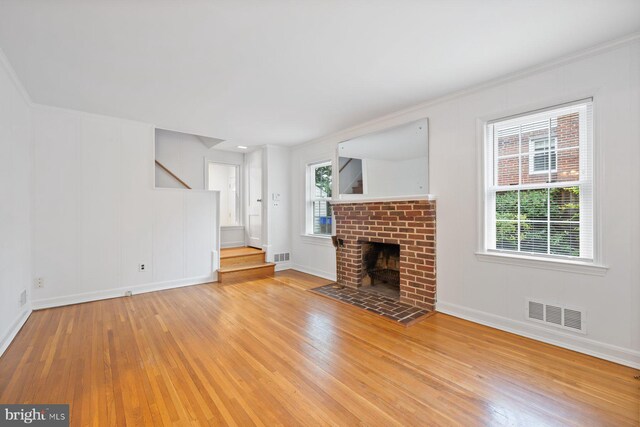 10402 Hayes Ave, Silver Spring, MD 20902 - unfurnished living room with hardwood / wood-style flooring, stairs, a brick fireplace, and baseboards