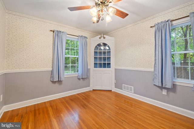 10402 Hayes Ave, Silver Spring, MD 20902 - unfurnished room featuring wood finished floors, ceiling fan, wallpapered walls, a wainscoted wall, and baseboards