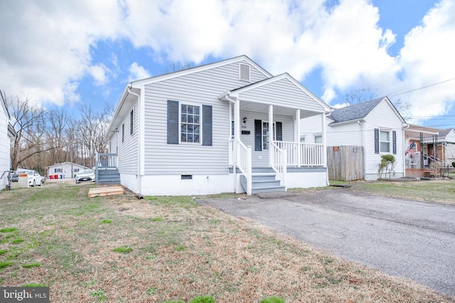 view of front of house with a porch, a front lawn, and crawl space