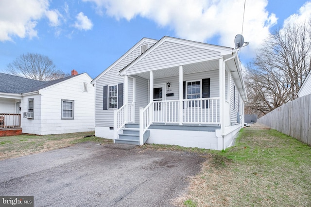 view of front of home featuring fence, a front yard, covered porch, cooling unit, and crawl space