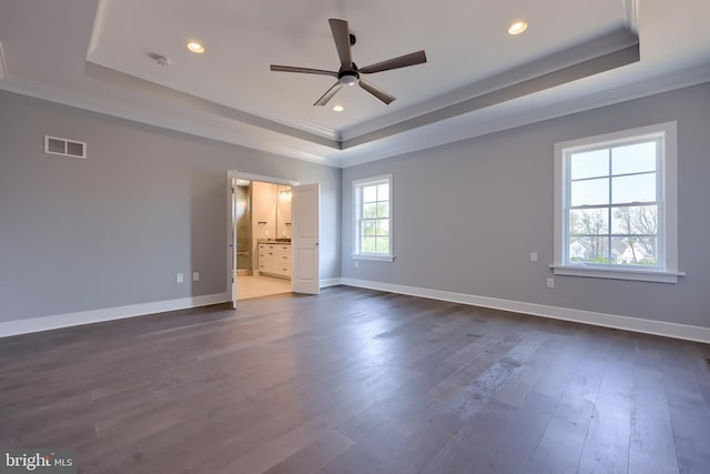 unfurnished bedroom featuring a tray ceiling, visible vents, and crown molding