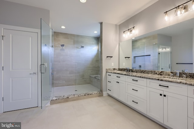 bathroom featuring double vanity, a stall shower, a sink, and recessed lighting