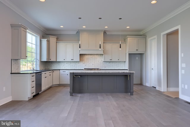 kitchen featuring dishwasher, a sink, a center island, and crown molding