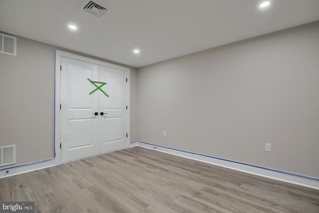 unfurnished room with wood finished floors, visible vents, and recessed lighting