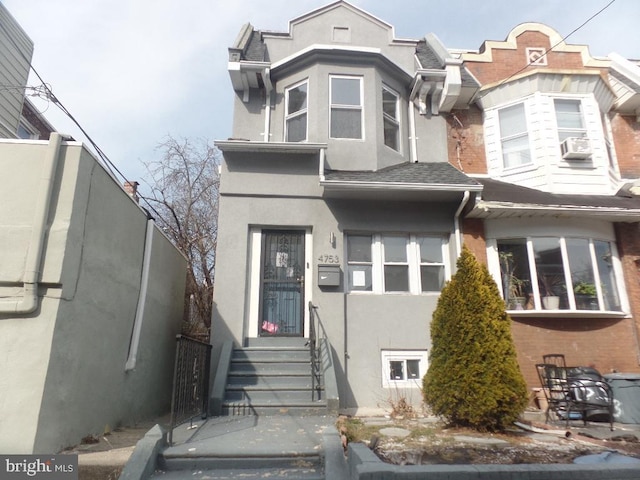 multi unit property featuring entry steps, a shingled roof, and stucco siding