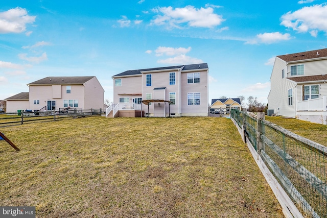 rear view of house featuring a fenced backyard, a yard, and central air condition unit