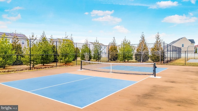 view of sport court with a residential view and fence