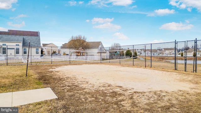 view of community featuring volleyball court, fence, and a residential view