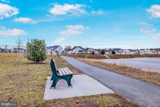 view of property's community featuring a yard, fence, and a residential view