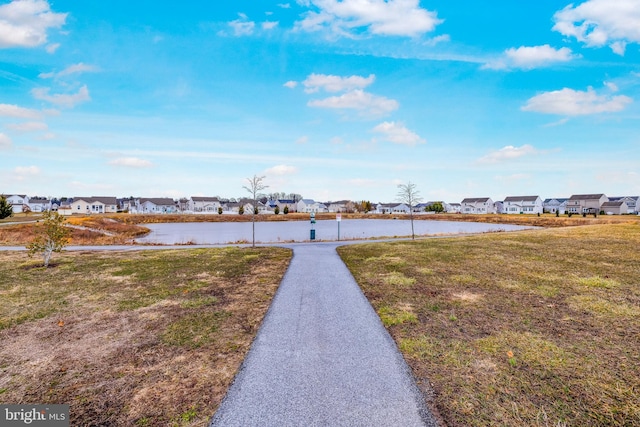 view of yard featuring a residential view and a water view