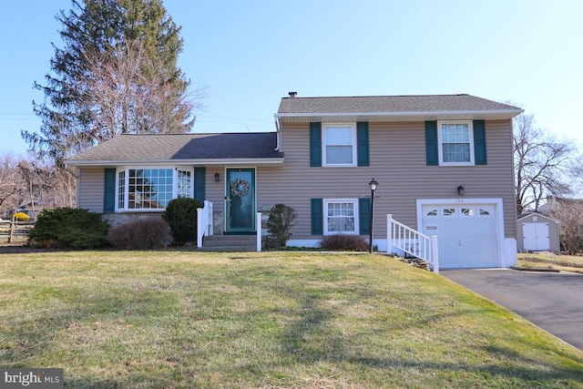 tri-level home with aphalt driveway, a garage, and a front yard