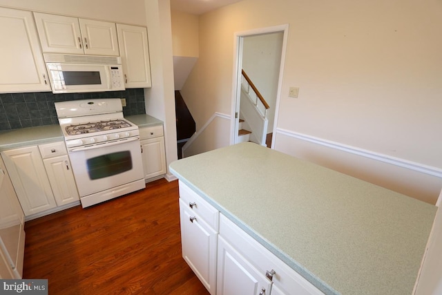 kitchen with white appliances, dark wood-style floors, decorative backsplash, light countertops, and white cabinetry