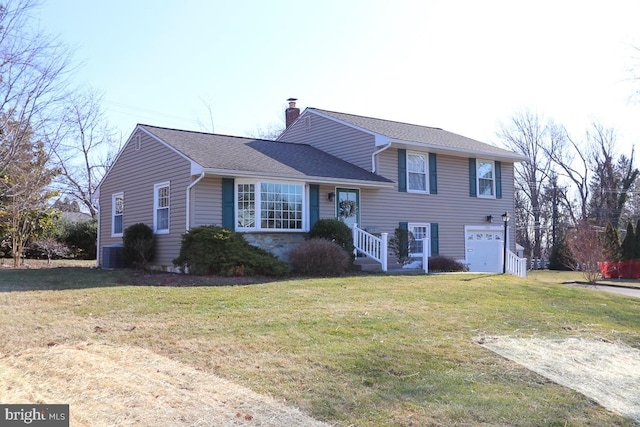 tri-level home featuring a shingled roof, a front lawn, central AC unit, a chimney, and a garage