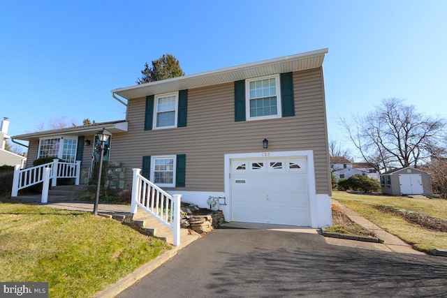 tri-level home with a front lawn, an outbuilding, a storage shed, and an attached garage