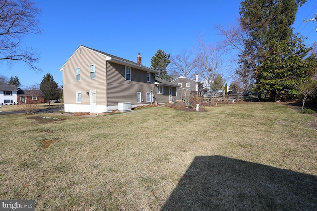 view of home's exterior with a lawn and a chimney