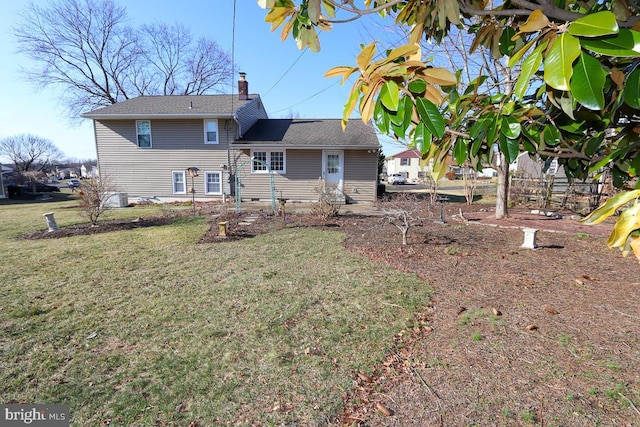 rear view of house with a yard and a chimney