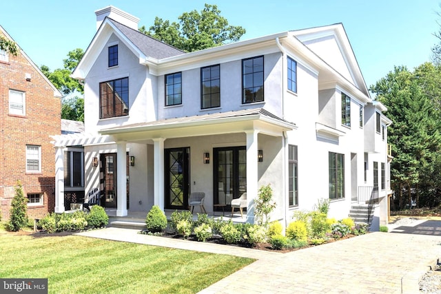 modern inspired farmhouse with covered porch, a front yard, french doors, and stucco siding