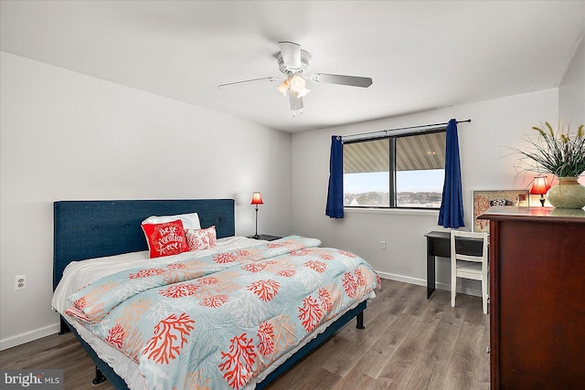 bedroom featuring ceiling fan, baseboards, and wood finished floors