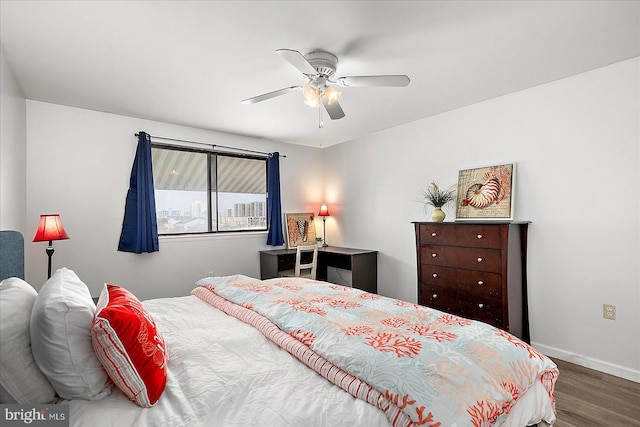 bedroom featuring wood finished floors, baseboards, and ceiling fan