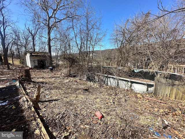 view of yard with a shed, fence, and an outdoor structure