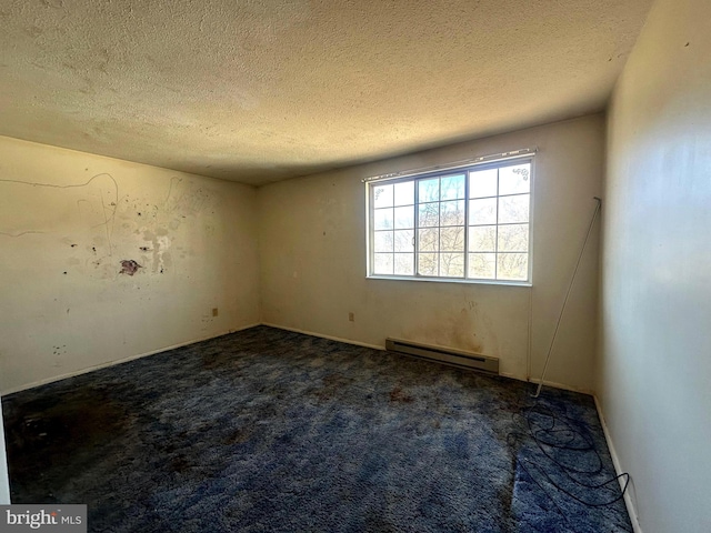 carpeted spare room featuring baseboard heating and a textured ceiling