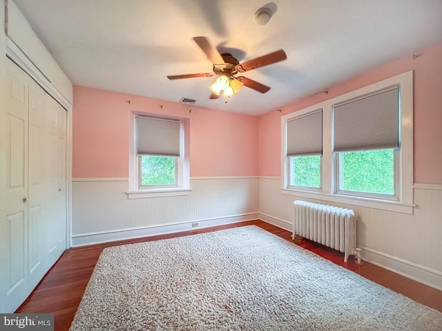 6 Washington Ave, Norristown, PA 19403 - unfurnished bedroom featuring radiator, wainscoting, dark wood-style flooring, a closet, and a ceiling fan