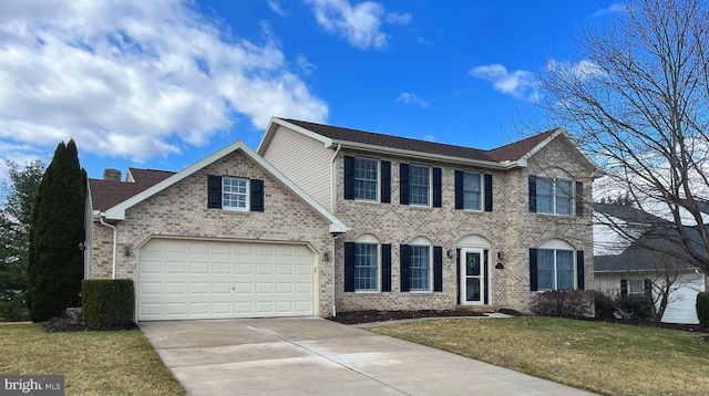 colonial home featuring concrete driveway, an attached garage, brick siding, and a front lawn