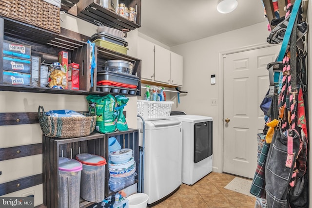 laundry area featuring light tile patterned flooring, cabinet space, and washing machine and clothes dryer