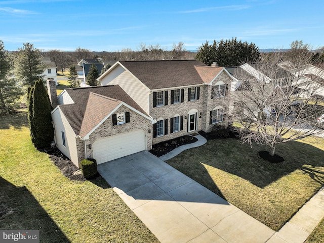 view of front facade featuring brick siding, a shingled roof, a front lawn, a chimney, and driveway