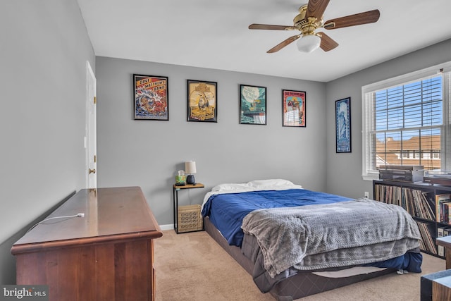 bedroom featuring a ceiling fan, baseboards, and light carpet